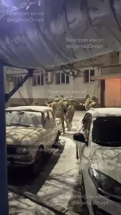 В Днепропетровске толпа ТЦКашников тянет полуголого мужика, по заснеженной дороге, к себе в машину, а следом бегут в помощь бедолаге девушки в одних халатах